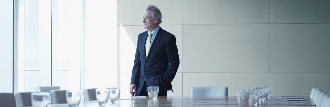 Businessman standing alone in conference room