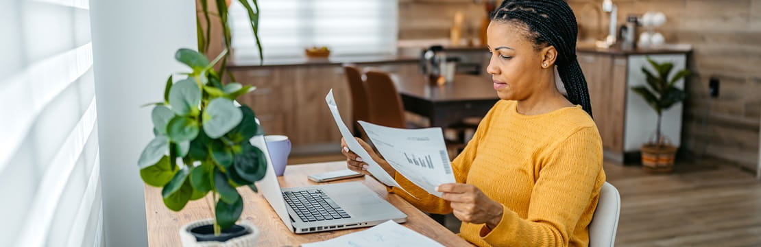 Woman sitting at desk reviewing documents.