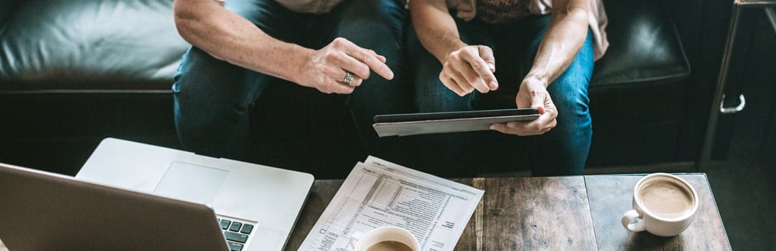 A mature adult couple has a discussion about their online tax process for their small business.